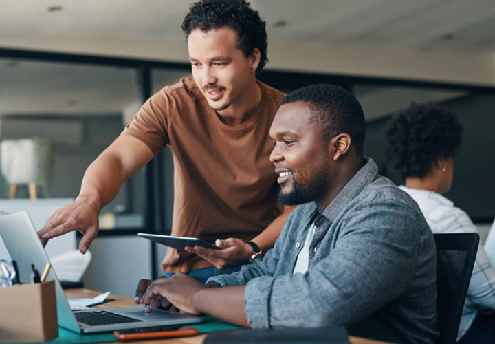 Two coworkers working together at a laptop.