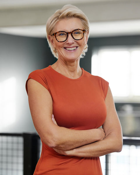 Woman smiling with her arms crossed.
