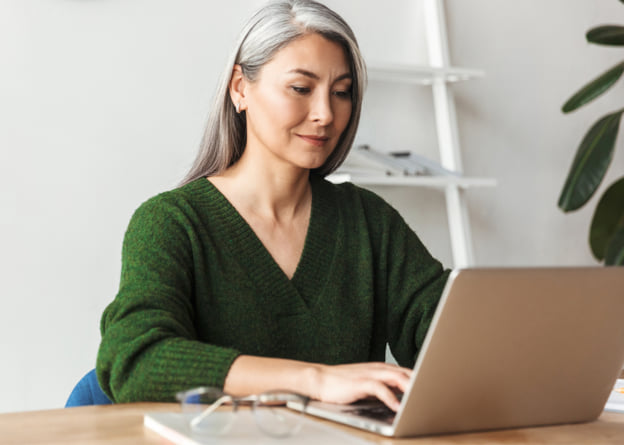 Woman working at a laptop representing taking an assessment.