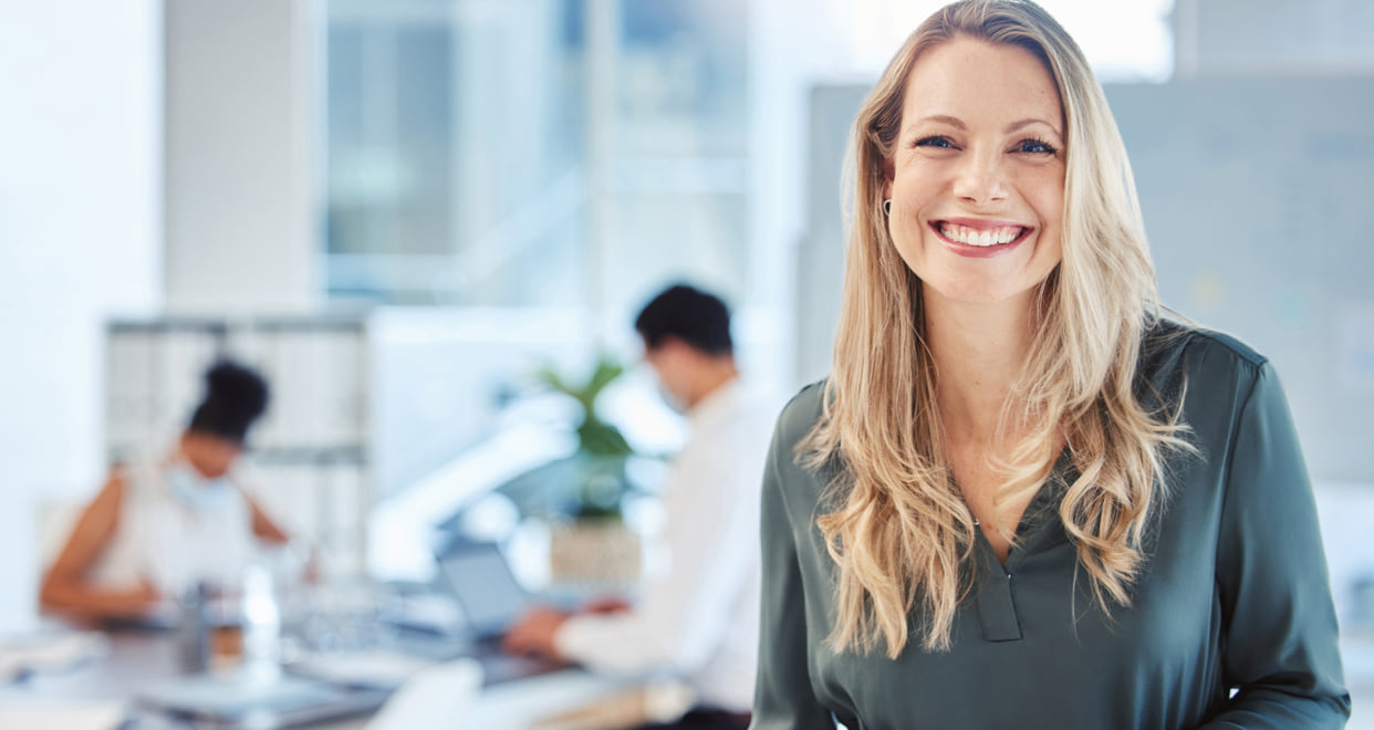Smiling executive woman in a bright office setting.