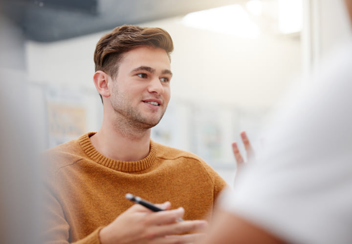 Young man student speaking in a group session.