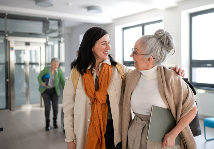 A student and a professor walking together in a hallway.