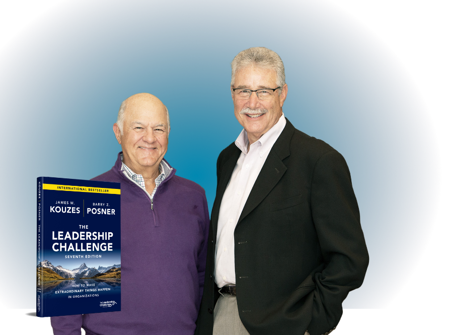 Authors Jim Kouzes and Barry Posner standing with the cover of their book, ‘The Leadership Challenge,’ in the bottom left corner.