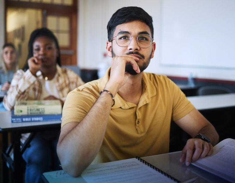 Young male student sitting at a desk in a classroom setting. A sample Student LPI 360 report is in the bottom right corner.
