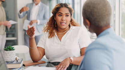 Woman speaking animatedly to her coworker.