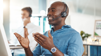 Man wearing a headset while talking animatedly.